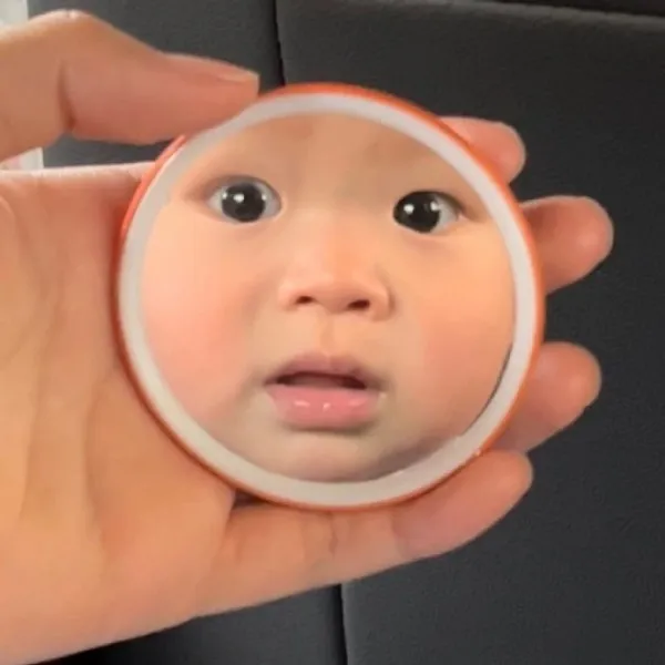 Có một em bé đang nhìn vào hình ảnh phản chiếu của nó trong gương