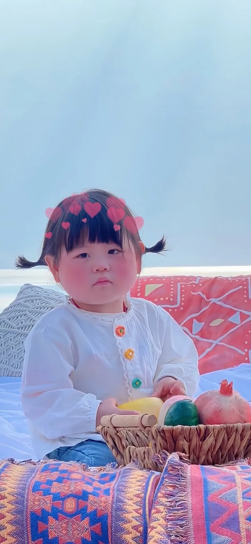 Một cô bé ngồi trên giường với một chiếc chăn hình nền em bé cute