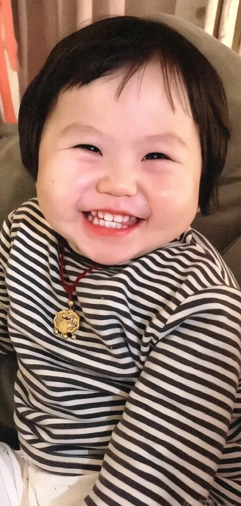 Một em bé ngồi trên ghế với nụ cười trên khuôn mặt hình nền em bé cute