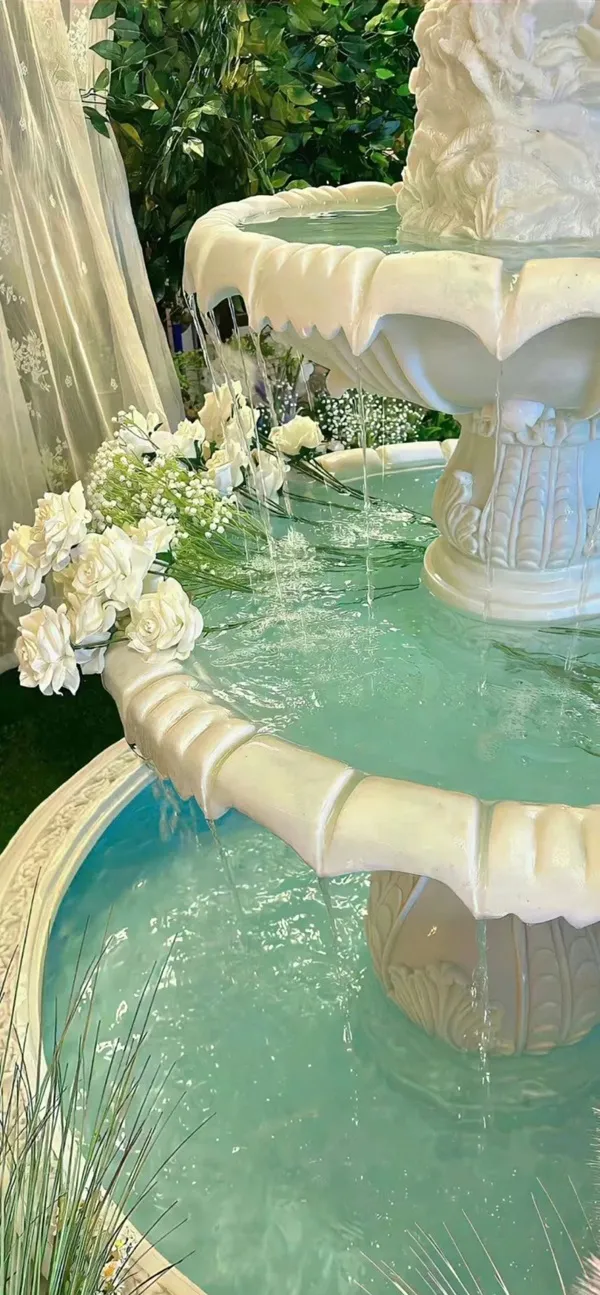 Một đài phun hình nền màu xanh lá cây nước với sự sắp xếp hoa ở giữa