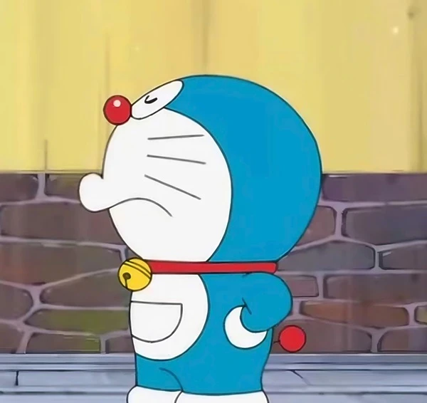 Một nhân vật hoạt hình trong bộ trang phục màu xanh meme chống nạnh