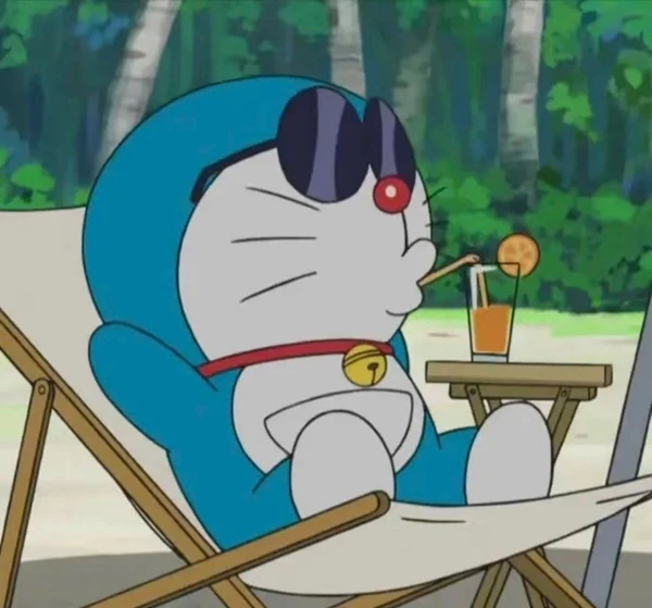 Một nhân vật hoạt hình ngồi trên ghế với một ly đồ uống meme doraemon