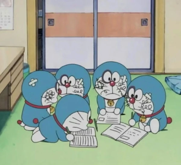 một nhóm các nhân vật hoạt hình ngồi quanh bàn meme doraemon
