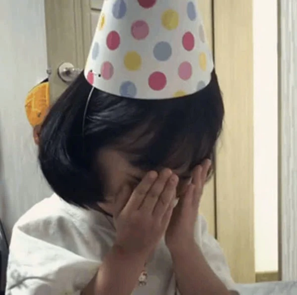 Một cô bé đội mũ sinh nhật meme ngại