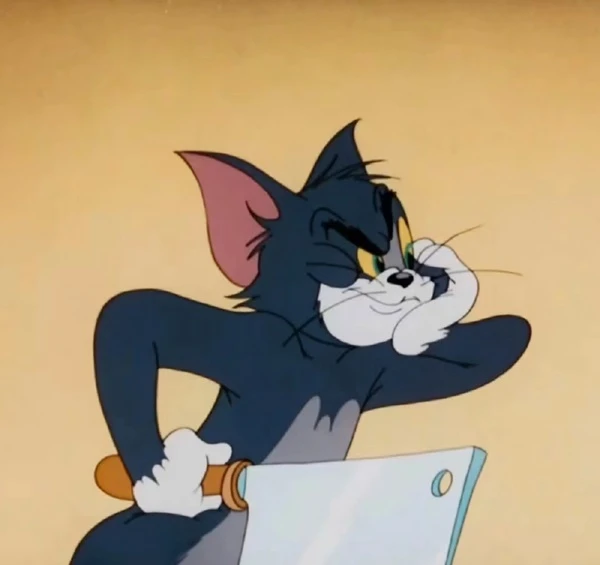 Hình nền meme tom and jerry: Một con mèo hoạt hình ngồi trên bàn
