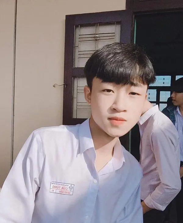 Ảnh trai đẹp đi học có một chàng trẻ đang đứng trước tòa nhà