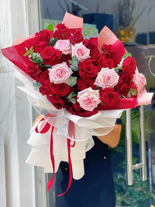 Một người phụ nữ cầm một bó hoa hồng đỏ và hồng ảnh hoa valentine