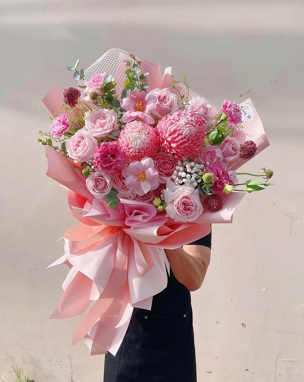 Một người phụ nữ cầm một bó hoa màu hồng ảnh hoa valentine