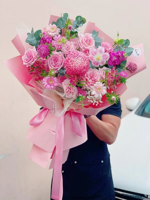 Một người phụ nữ cầm một bó hoa màu hồng ảnh hoa valentine