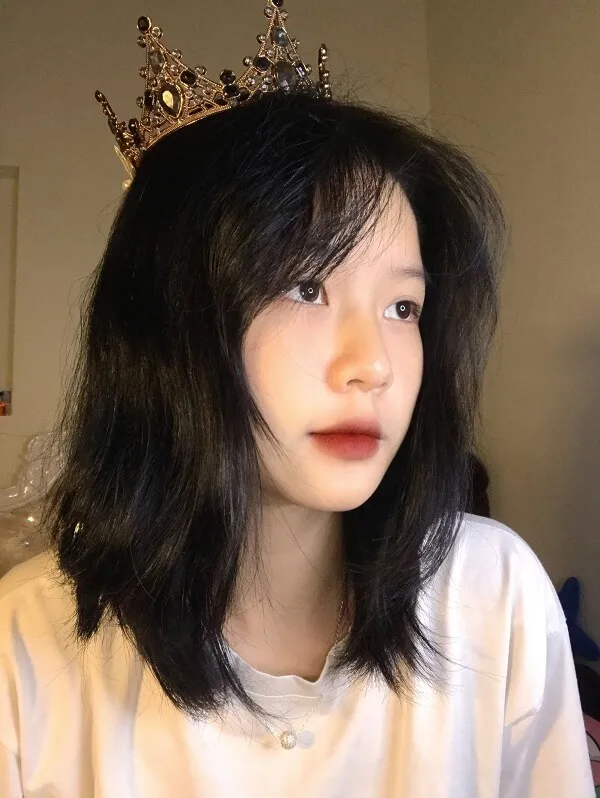 Ảnh 2k5 có một người phụ nữ vương miện trên đầu mặc áo sơ mi trắng