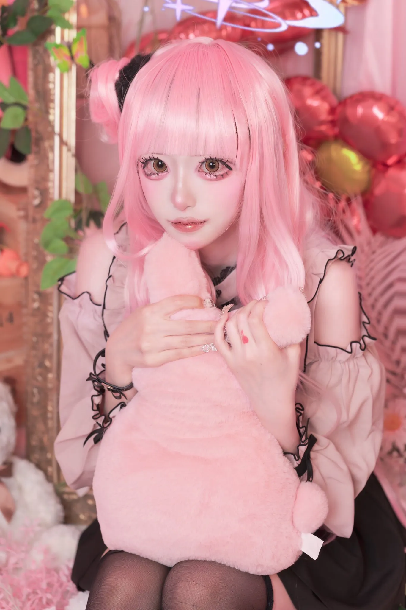 Ảnh amau ako cosplay có một người phụ nữ mái tóc màu hồng cầm con thú nhồi bông