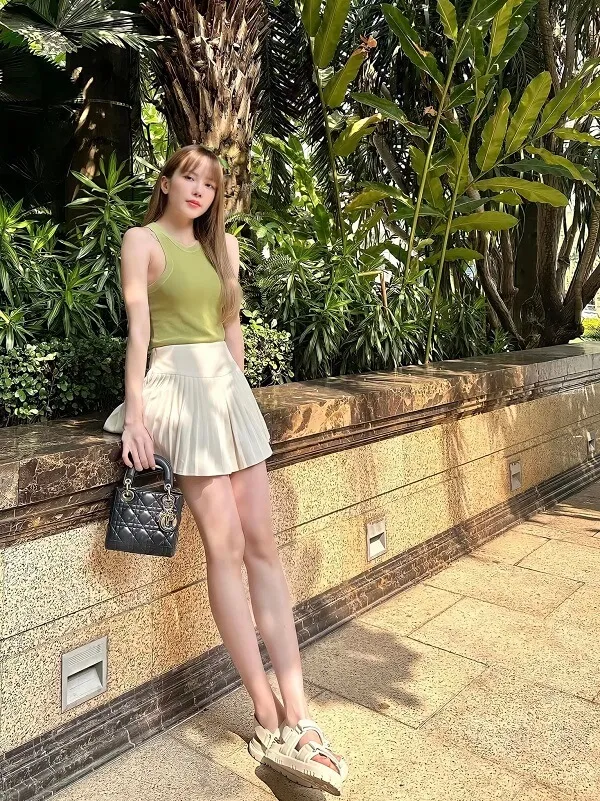 Ảnh bikini thiều bảo trâm có một người phụ nữ đang đứng bên bức tường với chiếc ví