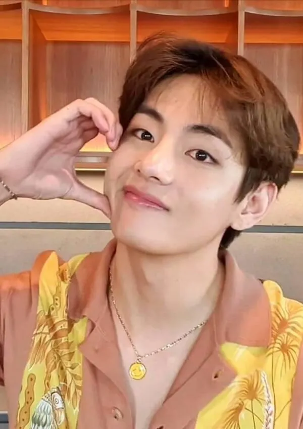Ảnh bts đây là một cận cảnh của người mặc áo sơ mi màu vàng