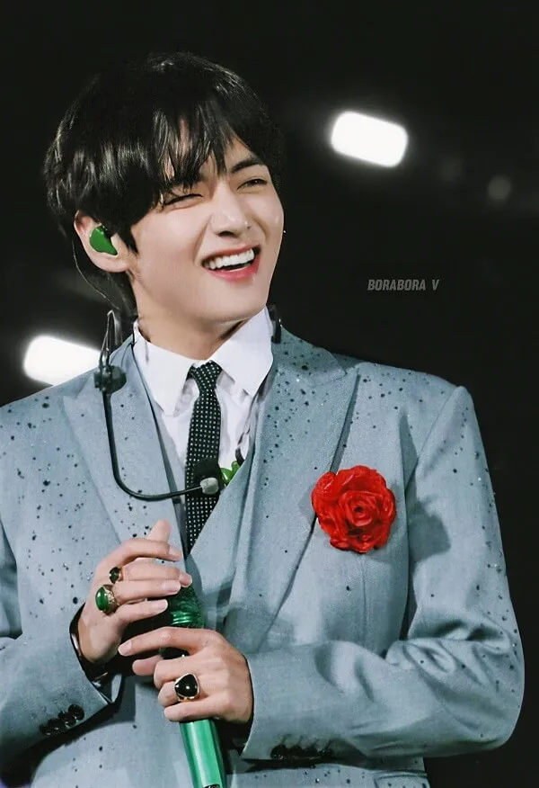 Ảnh bts cute có một người đàn ông trong bộ đồ và cà vạt cầm micro