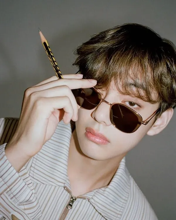Ảnh bts ngầu có một thanh niên đeo kính râm cầm bút chì trong tay