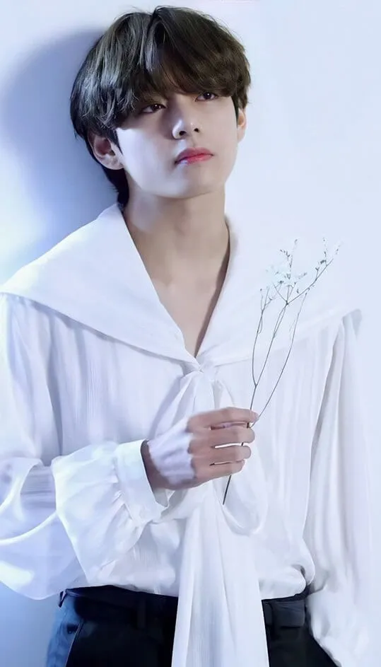 Ảnh bts mới nhất có một người đàn ông mặc áo sơ mi trắng cầm bó hoa