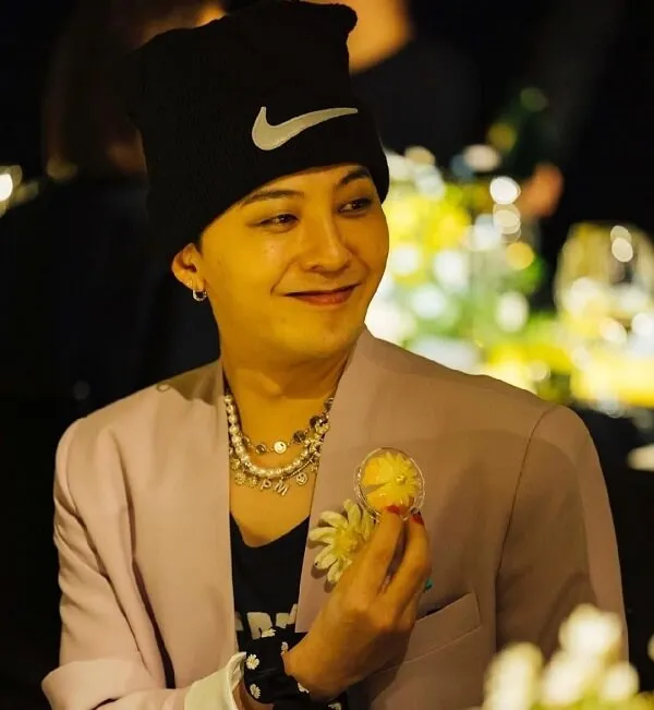 Ảnh của g-dragon có một người phụ nữ ngồi bàn với chiếc bánh trong tay