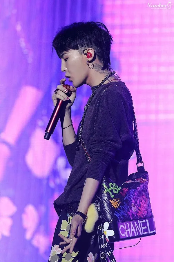 Ảnh của g-dragon người phụ nữ châu với mái tóc đen ngắn cầm micro trong tay
