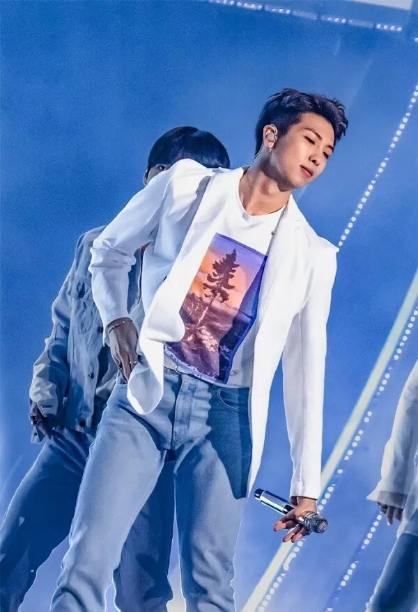 Ảnh rm bts có một người đàn ông đang đứng trên sân khấu với micro