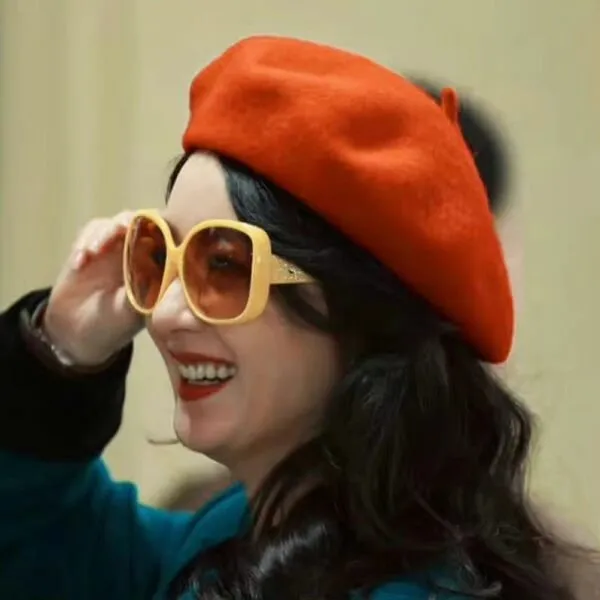 There is woman wearing red beret and yellow glasses