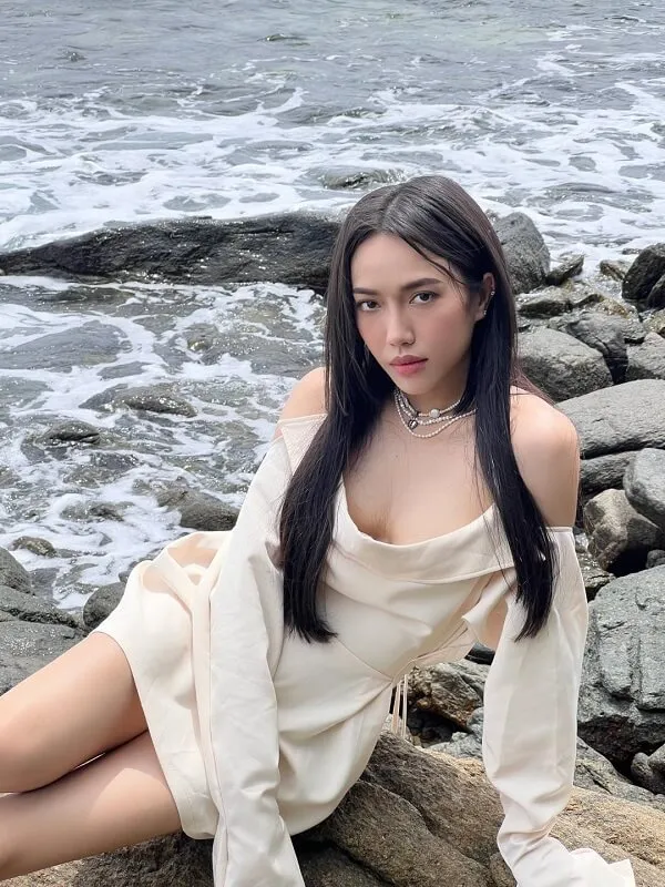 Bikini dieu nhi có một người phụ nữ đang ngồi trên số tảng đá bên nước