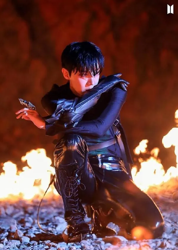 Ảnh j-hope bts có một người đàn ông đang quỳ xuống trước ngọn lửa