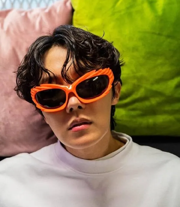 Ảnh dìm j-hope kính màu rực rỡ trên khuôn mặt của phụ nữ và một cái gối trong nền