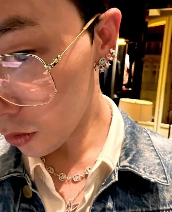 Ảnh của g-dragon có một người phụ nữ đeo kính và áo khoác denim nhìn vào điện thoại di động cô ấy