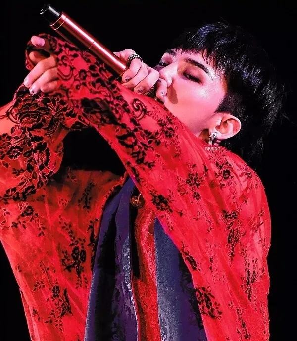 Ảnh của g-dragon có một người đàn ông đang cầm micro trong tay