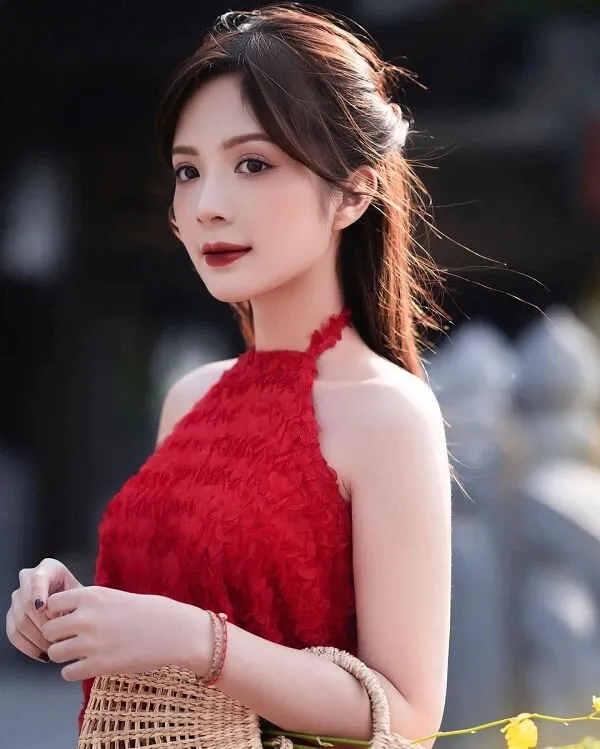 Ảnh gái xinh việt nam học sinh người phụ nữ trẻ mặc váy đỏ cầm giỏ đan lát và nhìn vào máy