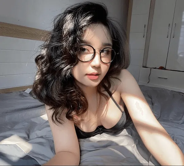 Ảnh gái xinh tóc dài đeo kính người phụ nữ châu gợi cảm với nằm trên giường trong phòng ngủ