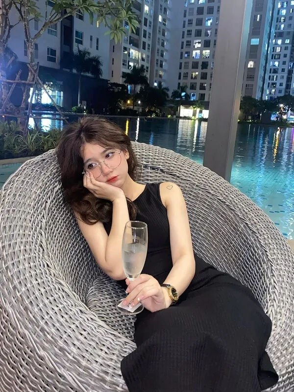 Gái xinh tóc dài đeo kính cute có một người phụ nữ ngồi trên ghế với ly rượu