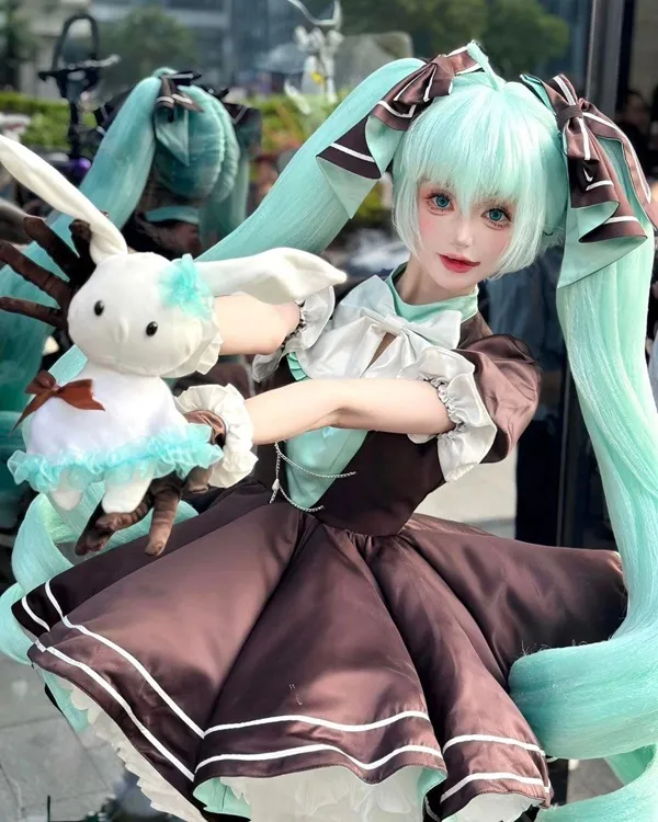 Ảnh hatsune miku cosplay có một người phụ nữ đang cầm con thú nhồi bông trong tay