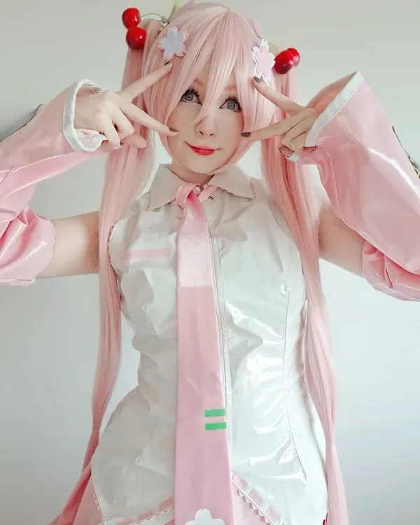 Ảnh hatsune miku cosplay có một người phụ nữ mái tóc màu hồng mặc áo sơ mi trắng và cà vạt