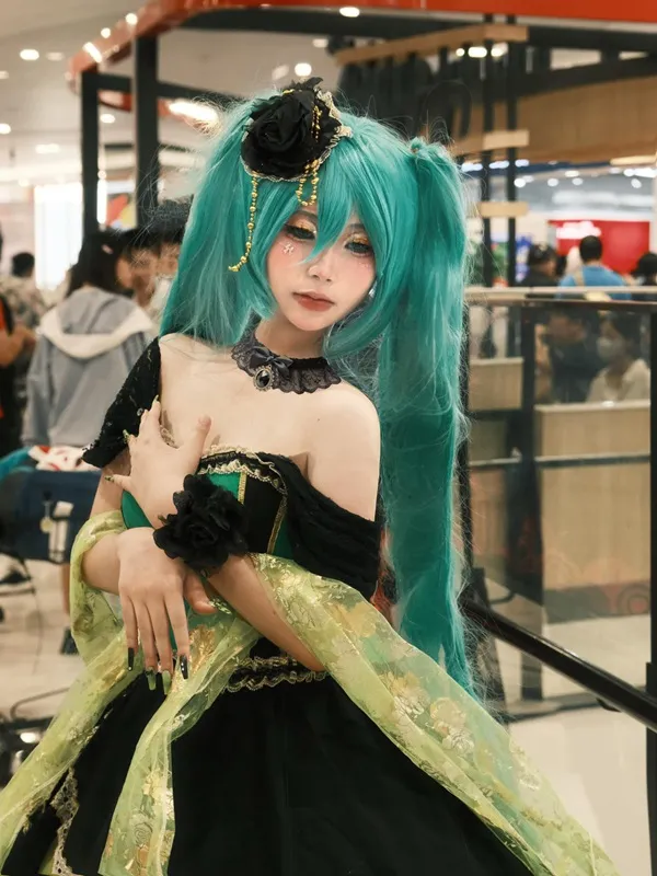 Ảnh hatsune miku cosplay có một người phụ nữ mái tóc xanh mặc váy màu lá cây và đen