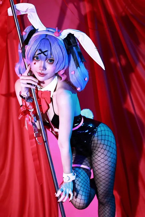 Ảnh hatsune miku cosplay người phụ nữ mặc trang phục bunny tạo dáng với một cột trước bức màn màu đỏ