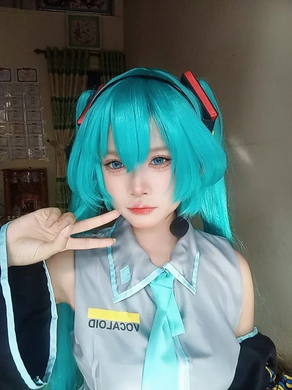 Ảnh hatsune miku cosplay có một người phụ nữ đang đội tóc giả màu xanh và cà vạt