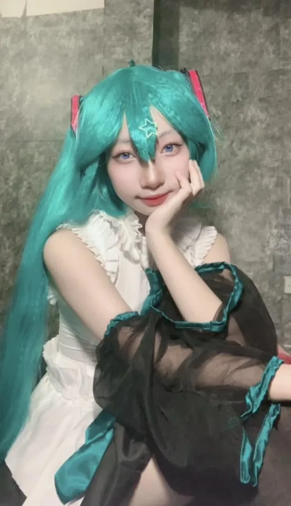 Ảnh hatsune miku cosplay có một người phụ nữ đang ngồi xuống với mái tóc xanh