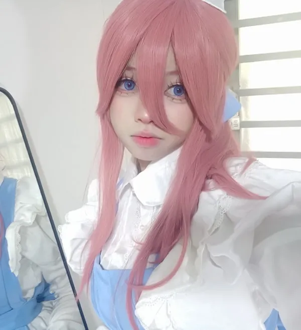 Ảnh hatsune miku cosplay có một người phụ nữ mái tóc hồng và đôi mắt xanh đang tạo dáng cho bức tranh
