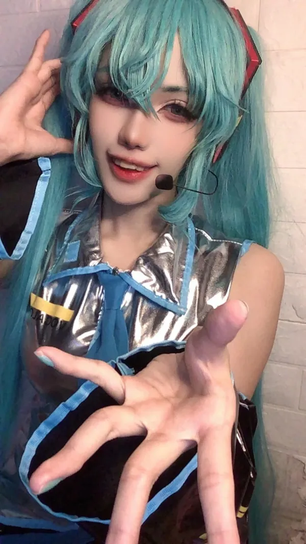 Ảnh hatsune miku cosplay có một người phụ nữ mái tóc xanh mặc trang phục và tai nghe