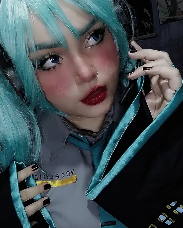 Ảnh hatsune miku cosplay có một người phụ nữ mái tóc xanh nói chuyện trên điện thoại di động