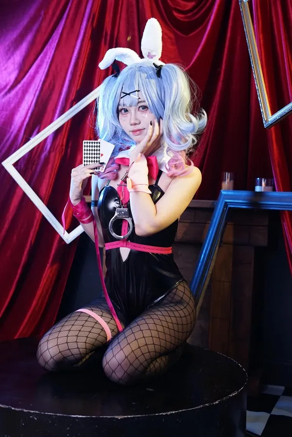 Ảnh hatsune miku cosplay có một người phụ nữ ngồi trên ghế đẩu với micro trong tay