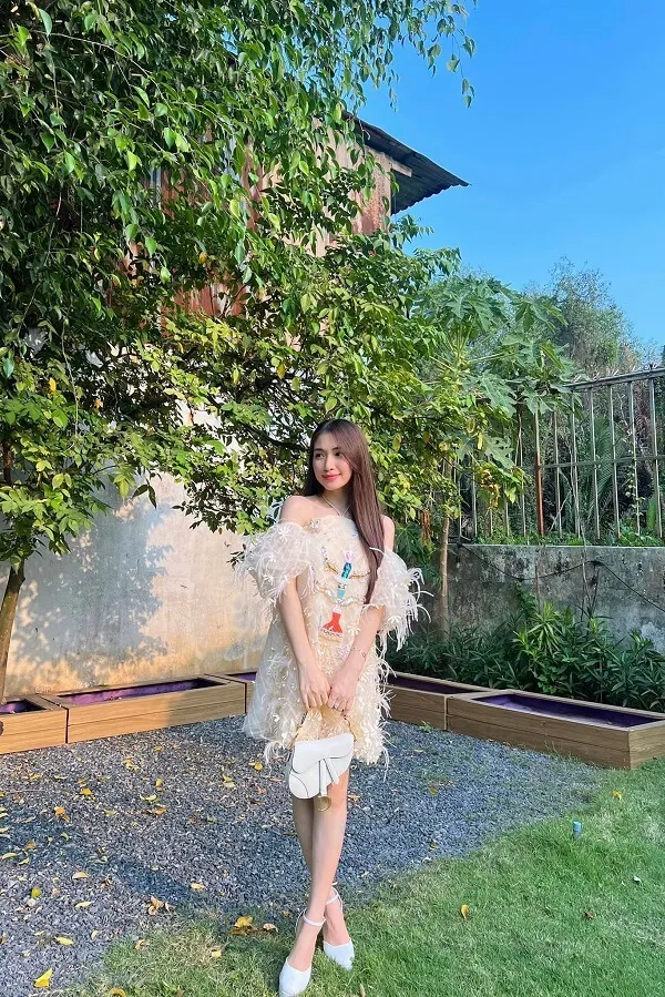 Ảnh hoà minzy sexy có một người phụ nữ đang đứng trên bãi cỏ gần cây