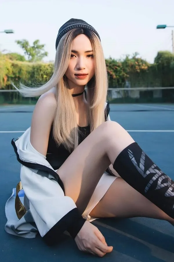 Ảnh hoà minzy sexy có một người phụ nữ đang ngồi trên mặt đất với cây vợt tennis