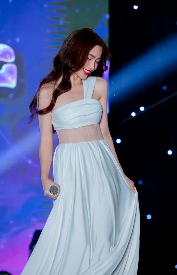 Ảnh hoà minzy sexy hình một người phụ nữ mặc váy trắng đứng trên sân khấu