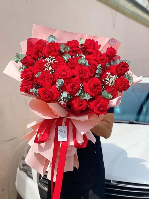 Một người phụ nữ cầm một bó hoa hồng đỏ ảnh hoa valentine