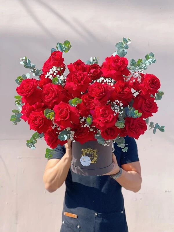 Một người phụ nữ cầm một bó hoa hồng đỏ ảnh hoa valentine