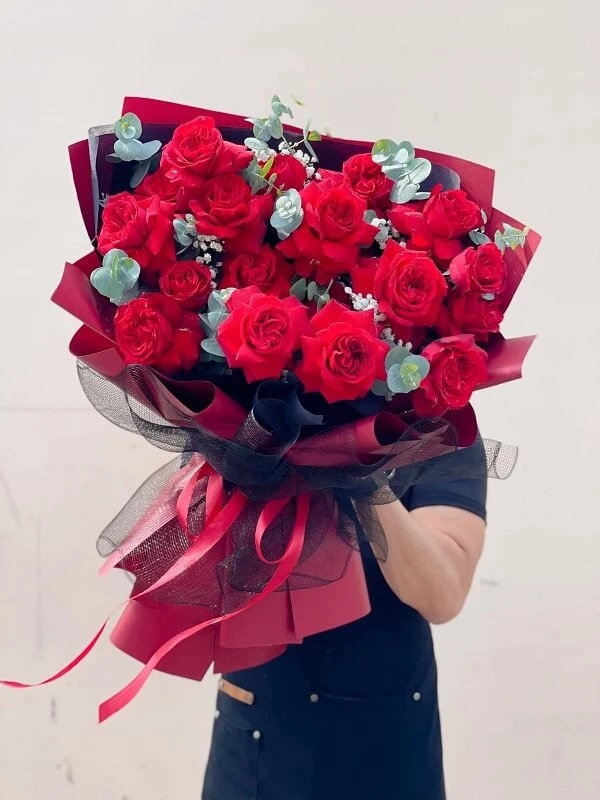 Một người phụ nữ cầm một bó hoa hồng đỏ ảnh hoa valentine