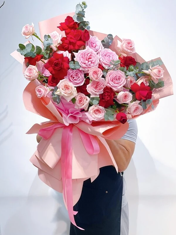 Một người phụ nữ cầm một bó hoa hồng và đỏ ảnh hoa valentine
