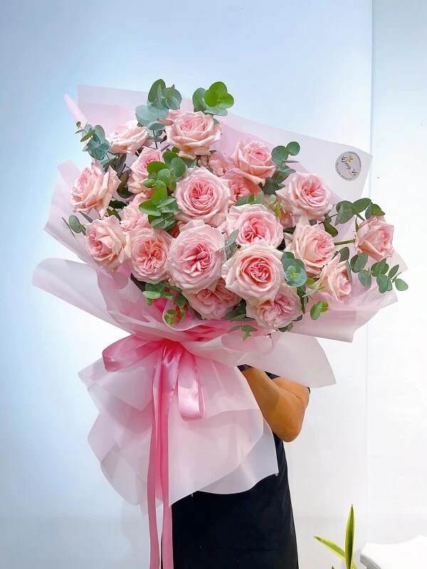 Một người phụ nữ cầm một bó hoa hồng ảnh hoa valentine